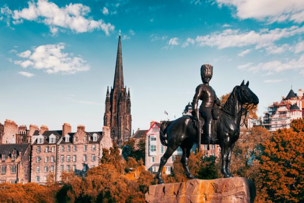 black statue of man riding horse near brown concrete building